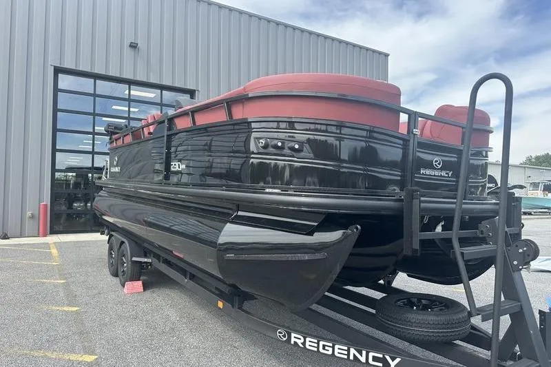 Slide: The Image of 2026 Regency 230 DL pontoon boat on trailer outside a modern building. - 4