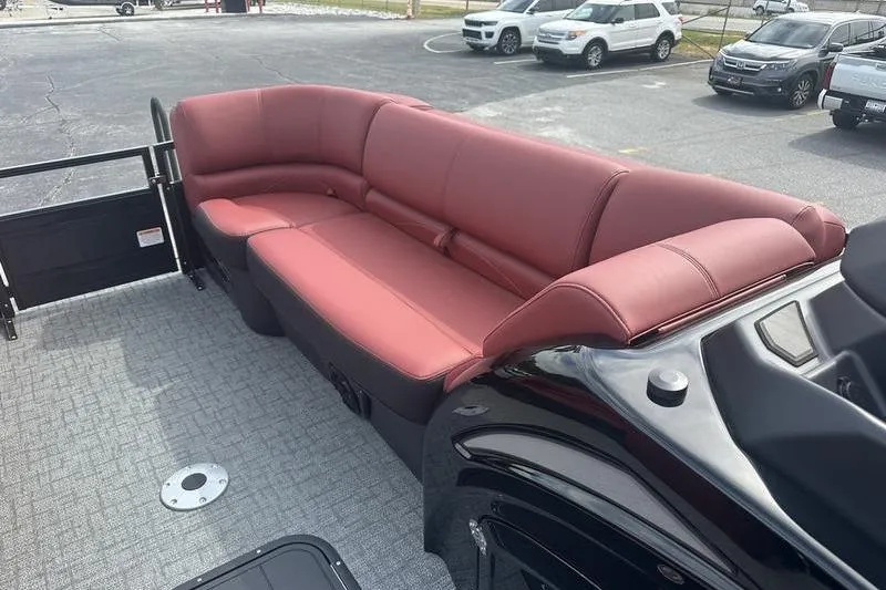 Slide: The Image of 2026 Regency 230 DL boat with red seating and gray flooring in a parking lot. - 8