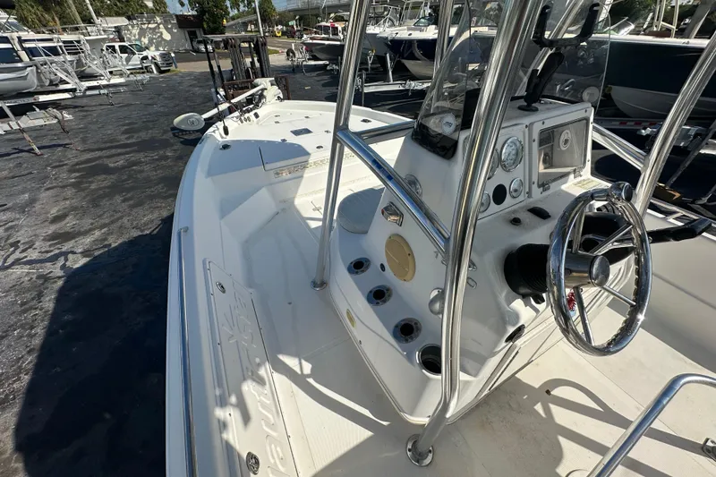 Slide: The Image of 2005 NauticStar 1900 NauticBay boat with steering console and gauges, docked in a marina. - 13