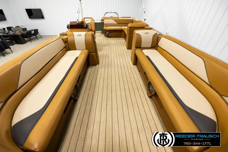 Slide: The Image of 2023 Avalon VEN CR boat interior with tan and cream seating, displayed in showroom. - 13