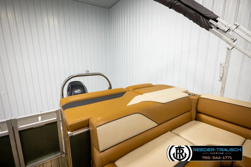 Slide: The Image of 2023 Avalon VEN CR boat interior with tan seating in a showroom. - 23