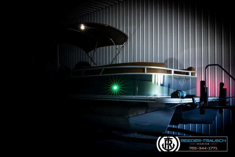 Slide: The Image of 2023 Avalon VEN CR boat in dimly lit storage, featuring sleek design and green navigation light. - 4