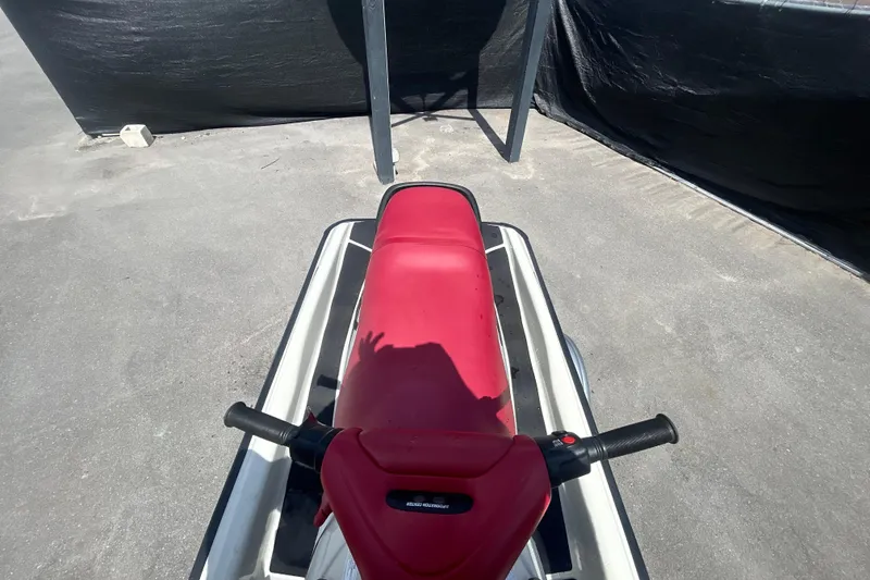 Slide: The Image of 1999 Sea Doo Jet Ski with red seat and handlebars, parked on concrete surface. - 13