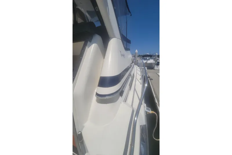 Slide: The Image of 1989 Navigator 34 Flybridge yacht docked, showcasing sleek design and railing details. - 10