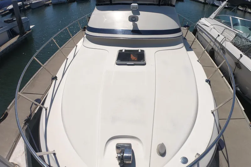 Slide: The Image of 1989 Navigator 34 Flybridge yacht docked at marina, showcasing spacious deck and sleek design. - 11