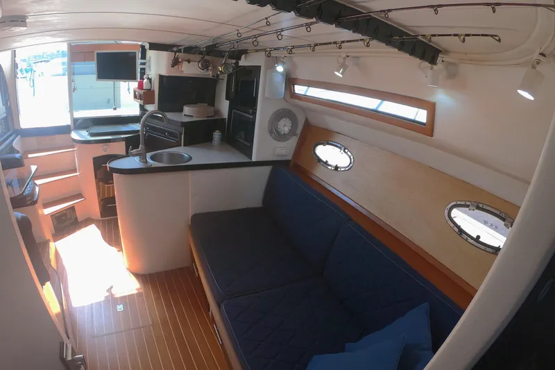 Slide: The Image of Interior of 1989 Navigator 34 Flybridge yacht with cozy seating and compact kitchen area. - 13