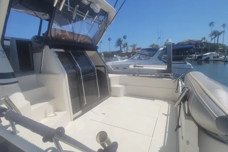 Slide: The Image of 1989 Navigator 34 Flybridge yacht docked in sunny marina with clear blue skies. - 2