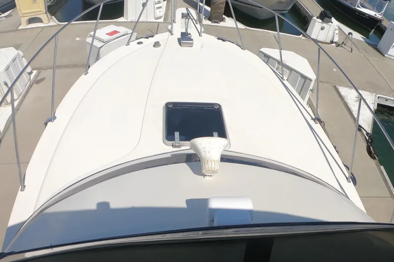 Slide: The Image of 1989 Navigator 34 Flybridge yacht deck view at marina, showcasing sleek design and railing. - 10