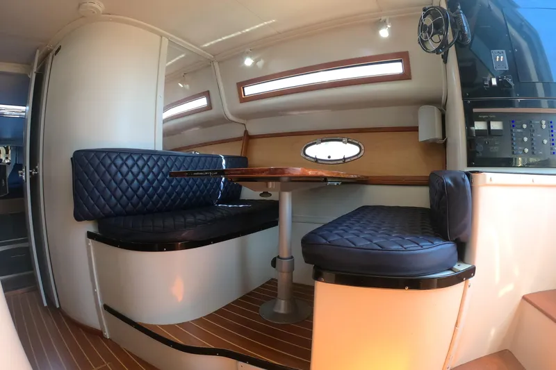 Slide: The Image of Interior of 1989 Navigator 34 Flybridge yacht with blue quilted seating and wooden table. - 17