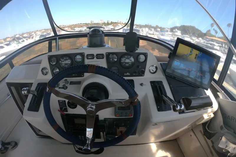 Slide: The Image of Cockpit of 1989 Navigator 34 Flybridge with steering wheel, gauges, and navigation screen. - 6