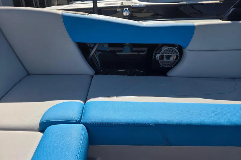Slide: The Image of 2022 MasterCraft NXT24 boat interior with blue and gray seating and speaker system. - 10