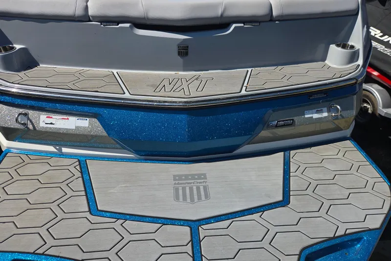 Slide: The Image of 2022 MasterCraft NXT24 boat rear deck with textured flooring and branding. - 12