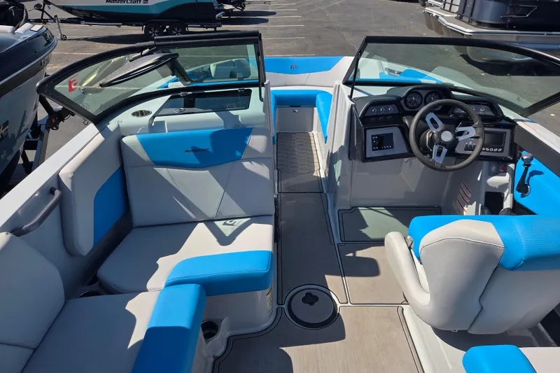 Slide: The Image of 2022 MasterCraft NXT24 boat interior with blue and white seating, modern dashboard, and steering wheel. - 5