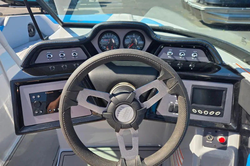 Slide: The Image of 2022 MasterCraft NXT24 boat dashboard with steering wheel and control panels. - 6