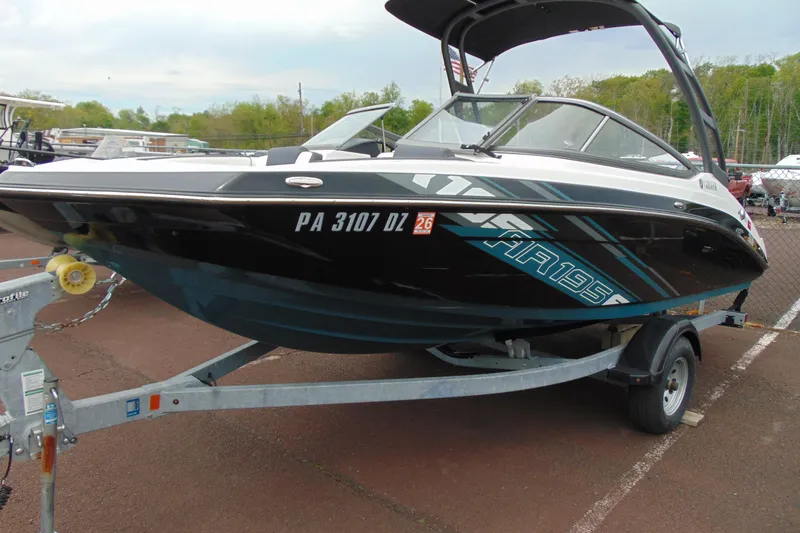 Slide: The Image of 2021 Yamaha Boats AR195 on trailer, sleek black design with blue accents. - 2