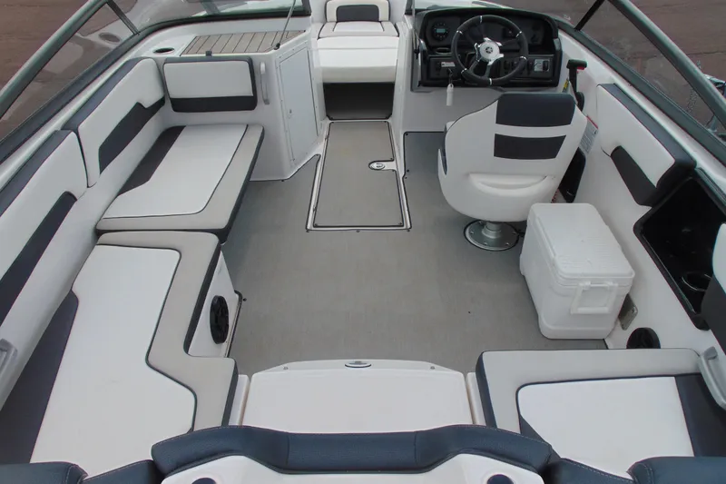 Slide: The Image of 2021 Yamaha Boats AR195 interior with seating, steering wheel, and cooler. - 6