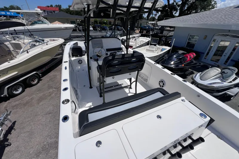 Slide: The Image of 2023 Twin Vee 240 GFX CC boat interior with seating and console, docked near other vessels. - 13