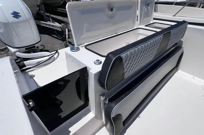 Slide: The Image of 2023 Twin Vee 240 GFX CC boat interior with storage compartments and Suzuki engine. - 17