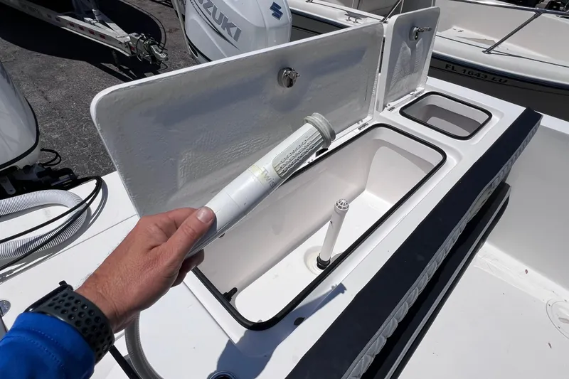 Slide: The Image of 2023 Twin Vee 240 GFX CC boat storage compartment with open lid and filter. - 18