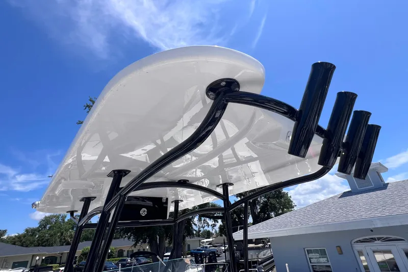 Slide: The Image of 2023 Twin Vee 240 GFX CC boat with sleek T-top design under clear blue sky. - 32