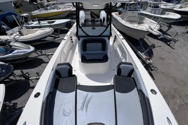 Slide: The Image of 2023 Twin Vee 240 GFX CC boat interior with seating and console, surrounded by other boats. - 42