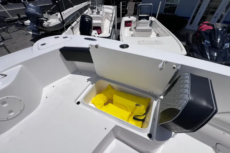 Slide: The Image of 2023 Twin Vee 240 GFX CC boat with open storage compartment and yellow life jacket. - 45
