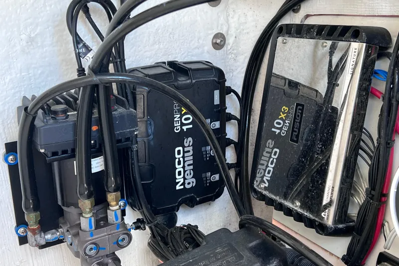 Slide: The Image of Electrical components inside a 2023 Twin Vee 240 GFX CC boat, featuring NOCO Genius chargers. - 47