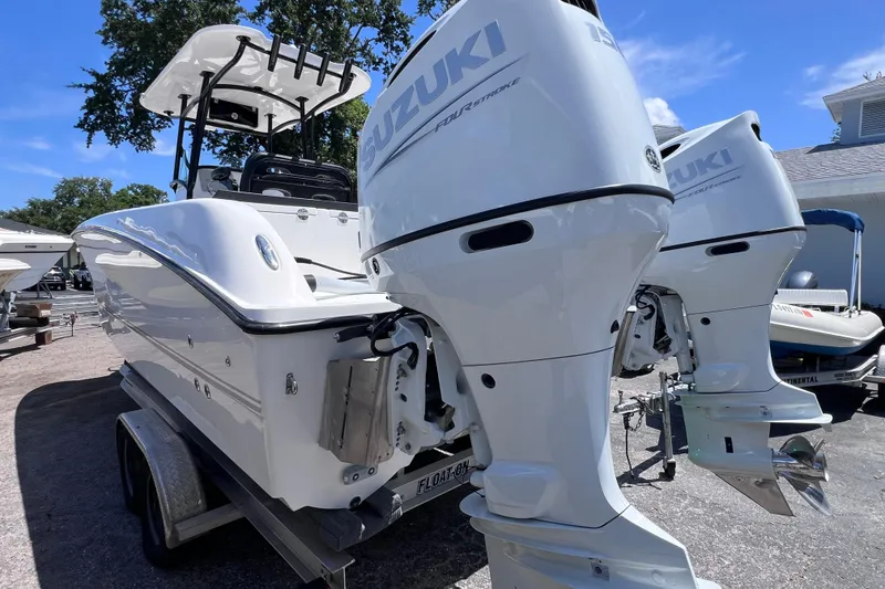 Slide: The Image of 2023 Twin Vee 240 GFX CC boat with dual Suzuki outboard motors on a trailer. - 6