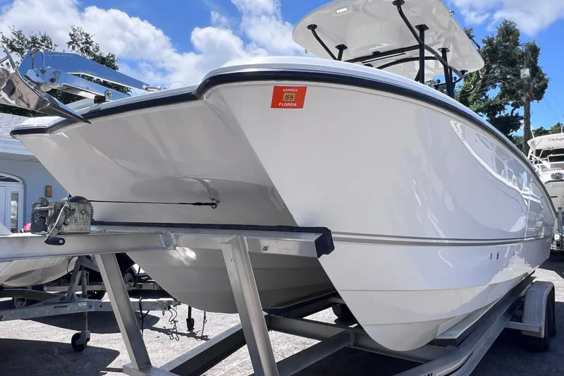 Slide: The Image of 2023 Twin Vee 240 GFX CC boat on trailer under blue sky. - 8