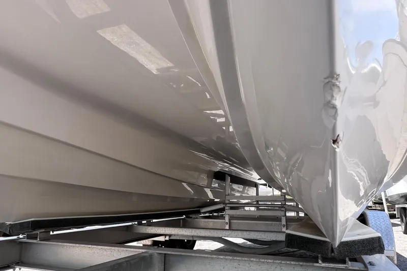 Slide: The Image of 2023 Twin Vee 240 GFX CC boat hull on trailer, showing minor damage. - 9