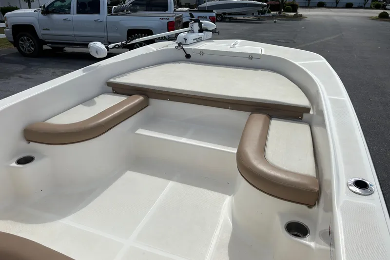 Slide: The Image of 2021 Sundance DX22 boat interior with cushioned seating and fishing rod holders. - 10