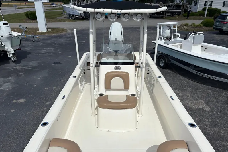 Slide: The Image of 2021 Sundance DX22 boat with center console and seating, displayed outdoors. - 11