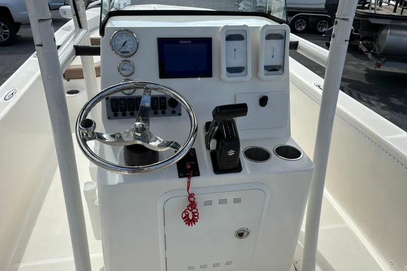 Slide: The Image of 2021 Sundance DX22 boat console with steering wheel, gauges, and controls. - 14