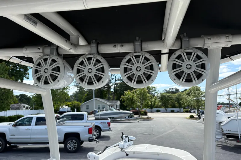 Slide: The Image of 2021 Sundance DX22 boat with mounted Kicker speakers on the T-top frame. - 17