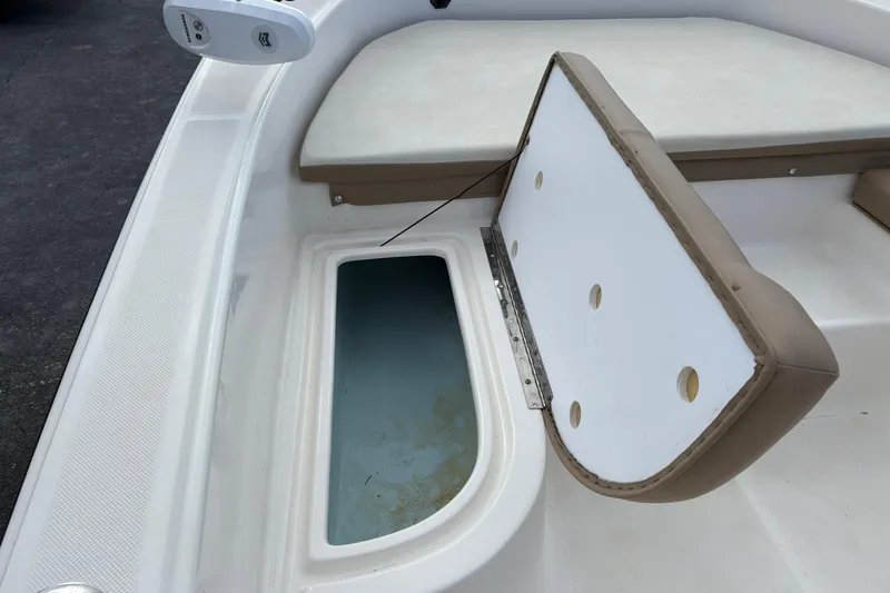 Slide: The Image of Open storage compartment on 2021 Sundance DX22 boat, featuring cushioned seating. - 18