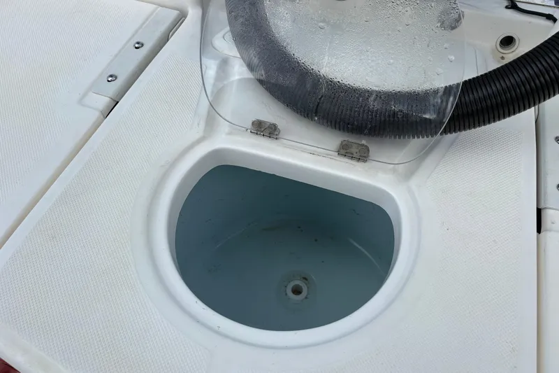 Slide: The Image of Livewell compartment on a 2021 Sundance DX22 boat, featuring a clear lid and drainage. - 19