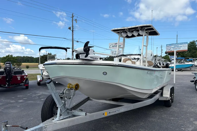 Slide: The Image of 2021 Sundance DX22 boat on trailer, displayed outdoors under a clear blue sky. - 2