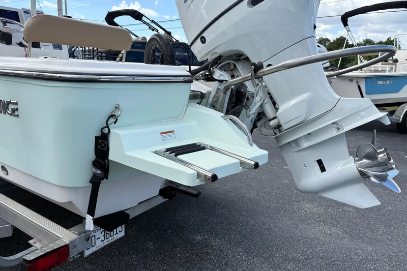 Slide: The Image of 2021 Sundance DX22 boat with outboard motor and swim platform on trailer. - 8