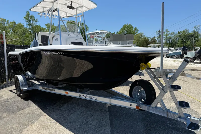 Slide: The Image of 2024 Tidewater 198 CC Adventure boat on trailer, parked outdoors. - 11