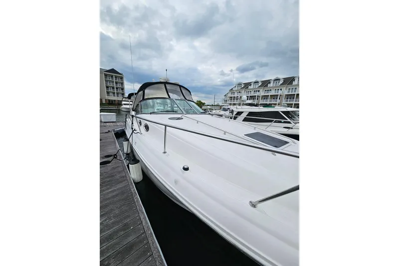 The Image of 2006 Sea Ray Sundancer 320 docked at marina, cloudy sky backdrop. - 0