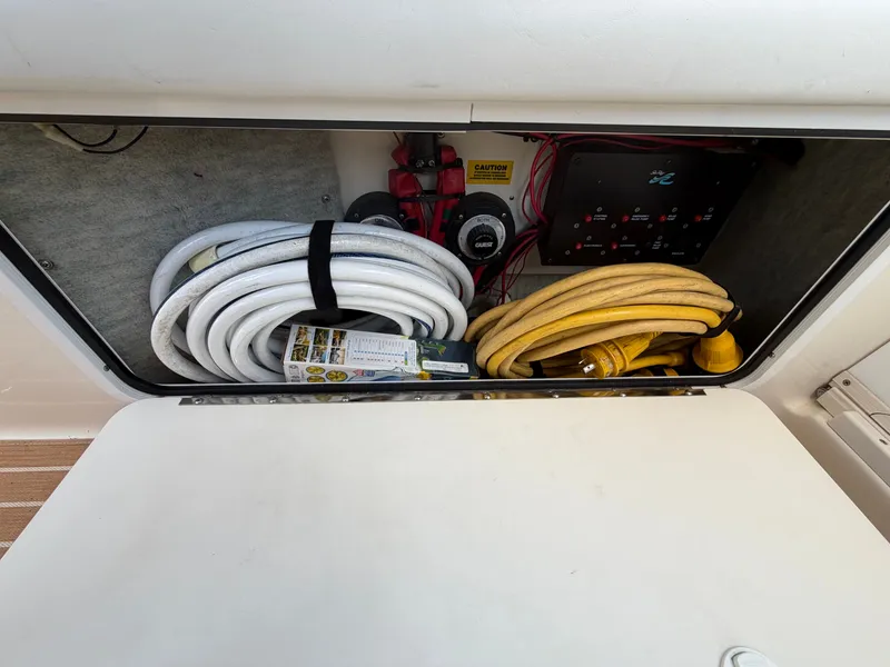 Slide: The Image of Storage compartment in 1996 Sea Ray 290 Sundancer with cables and hoses. - 12