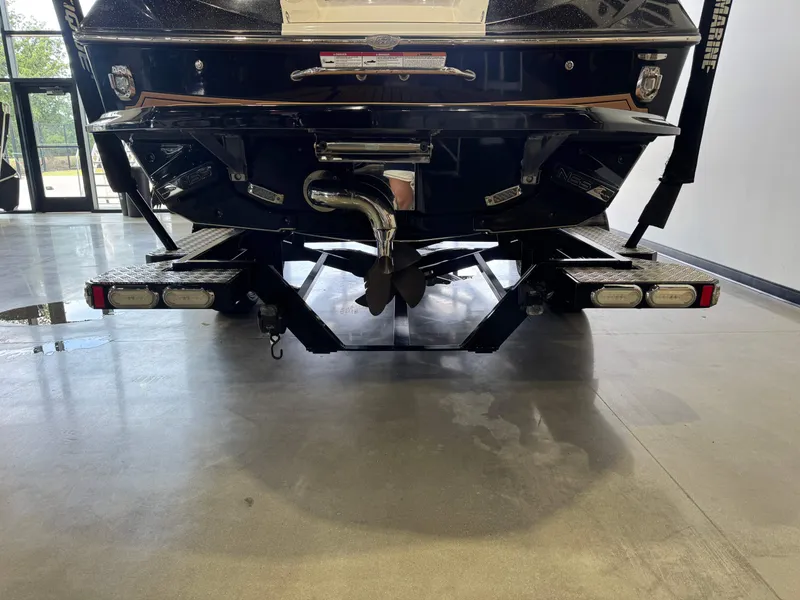 Slide: The Image of Rear view of a 2019 Nautique Super Air Nautique G21 boat indoors. - 7