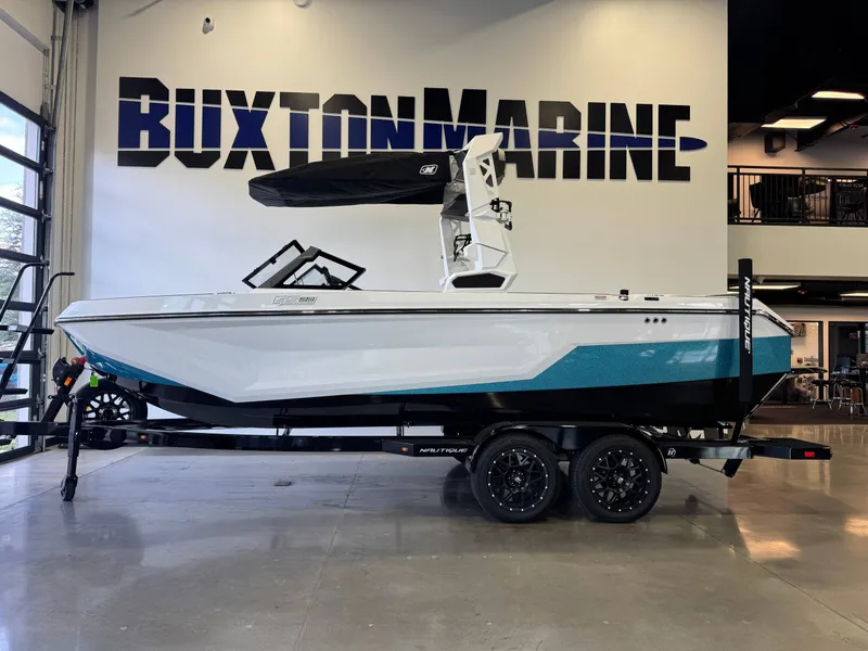Slide: The Image of A white and blue boat on a trailer in a showroom. - 4
