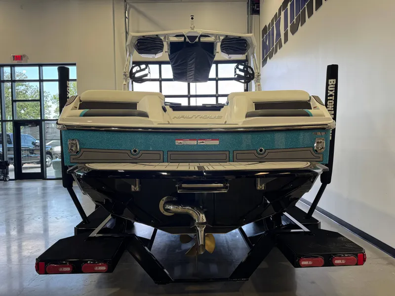 Slide: The Image of The image shows the rear of a Nautique Super Air Nautique GS22 boat in a showroom. - 6