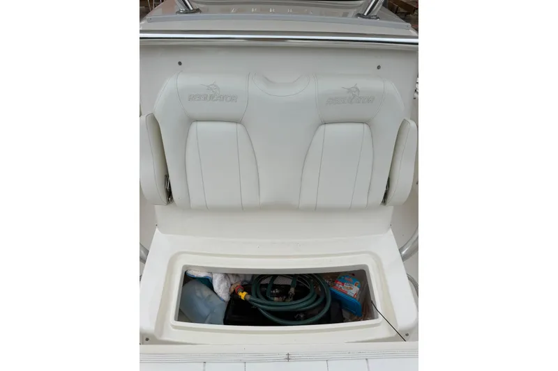 Slide: The Image of 2018 Regulator 31 boat seat with storage compartment open, showing equipment inside. - 13