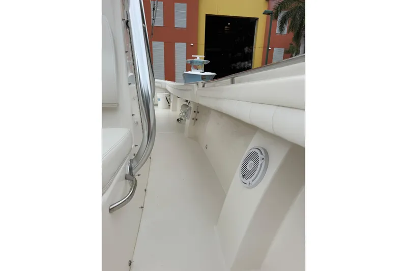 Slide: The Image of 2018 Regulator 31 boat interior with seating and speaker, docked near colorful building. - 15
