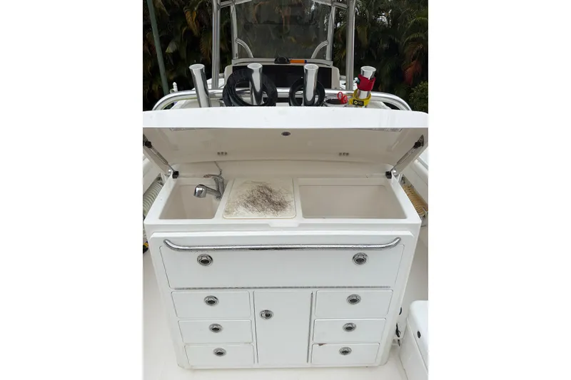 Slide: The Image of 2018 Regulator 31 boat with open storage compartment and sink, featuring multiple drawers. - 23