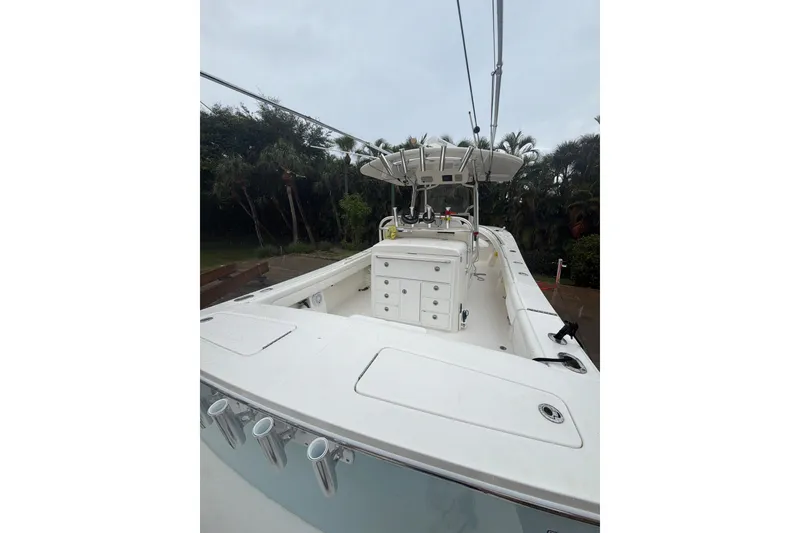Slide: The Image of 2018 Regulator 31 boat with center console and rod holders, surrounded by lush greenery. - 25
