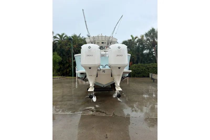 Slide: The Image of 2018 Regulator 31 boat with twin 300 horsepower engines, parked on wet pavement. - 27