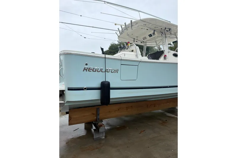Slide: The Image of 2018 Regulator 31 boat on dry dock, light blue hull, fishing rods visible. - 3